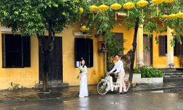 Vietnam Hoi An antik kasabasında çiçekli gelin ve bisikletli damat