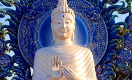 Mavi arka fonun önünde bembeyaz buddha heykeli