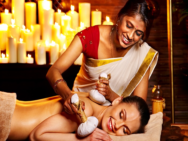 Hintli kadına ayurveda masaj yaptıran turist kadın