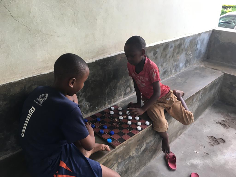 Karşı karşıya dama oynayan Afrikalı iki çocuk