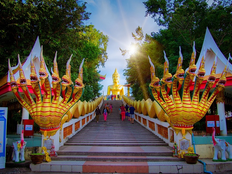 Uzun merdivenlerin en altından yukarı doğru uzanan yılan çeklinde tırabzanlar ve yukarıda altın sarısı buda heykeli