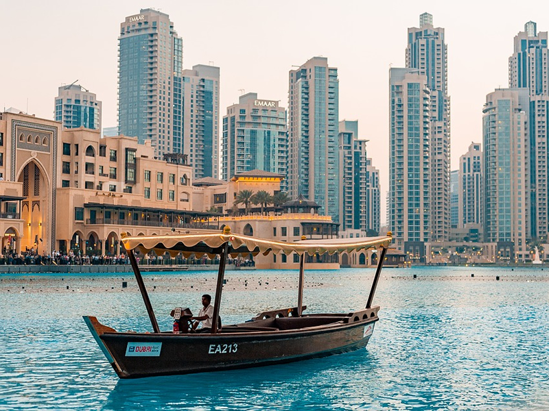 Dubai'de nehrin üzerinde tekne ve kıyısında görünen binalar
