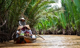 Camurlu bir nehirde tekneye binmiş dört vietnamlı kadın